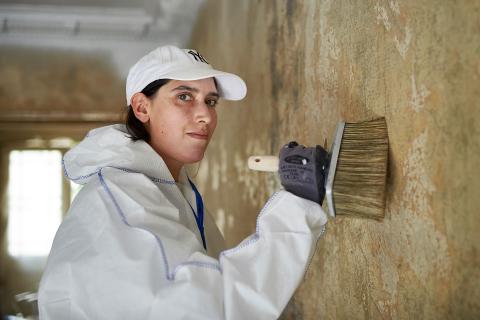 Eine Mitarbeiterin von Malerei Palette beim Kleistern