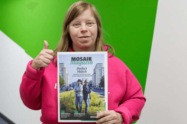 Redaktionsmitglied Sabine Zobel präsentiert stolz die neueste Ausgabe des Mosaik Magazins