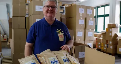 André auf seinem Außenarbeitsplatz bei Knalle Popkorn, gerade verpackt er Tüten für den Versand