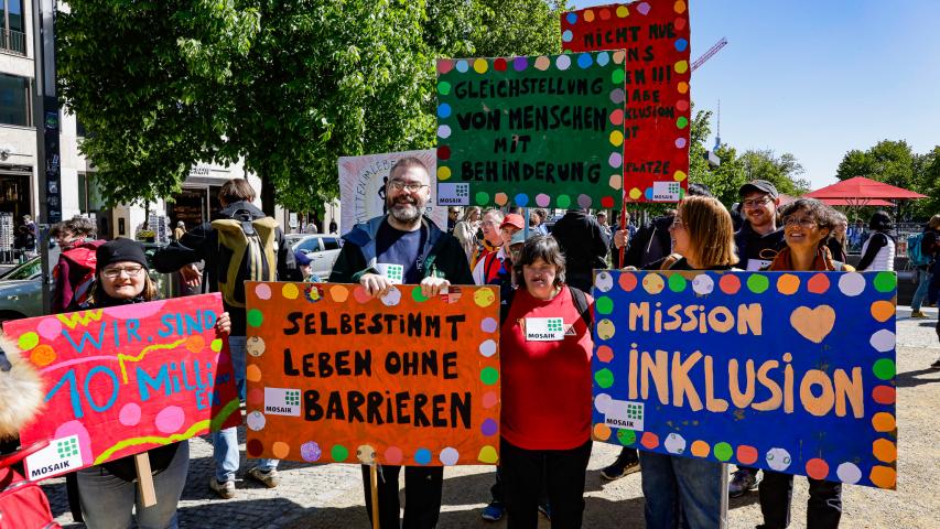 Mosaik Beschäftigte und Teilnehmende halten Protestschilder