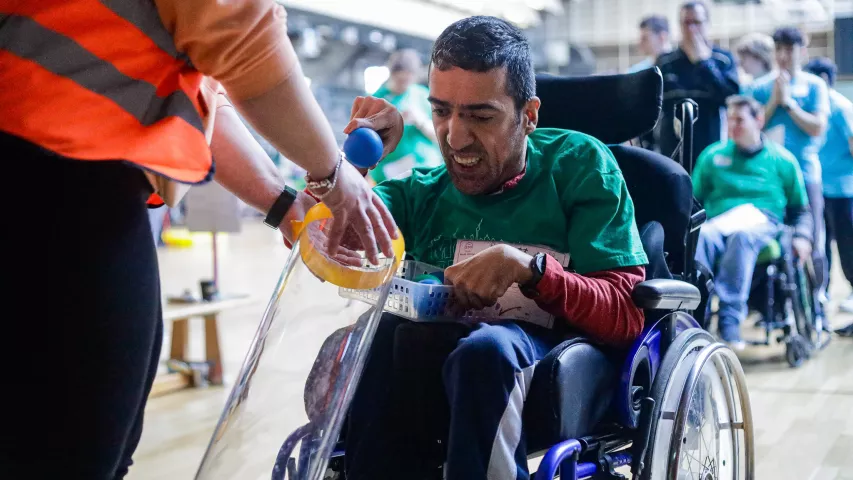 Ein Mann mit Rollstuhl spielt ein Ballspiel