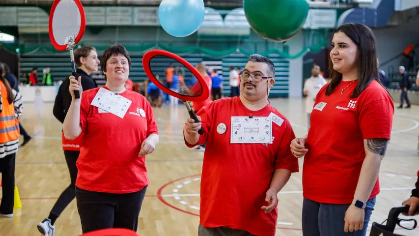 3 Menschen spielen Tennis mit einem Ballon
