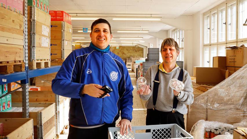 Zwei Mitarbeiter aus dem Versand in der Lagerhalle